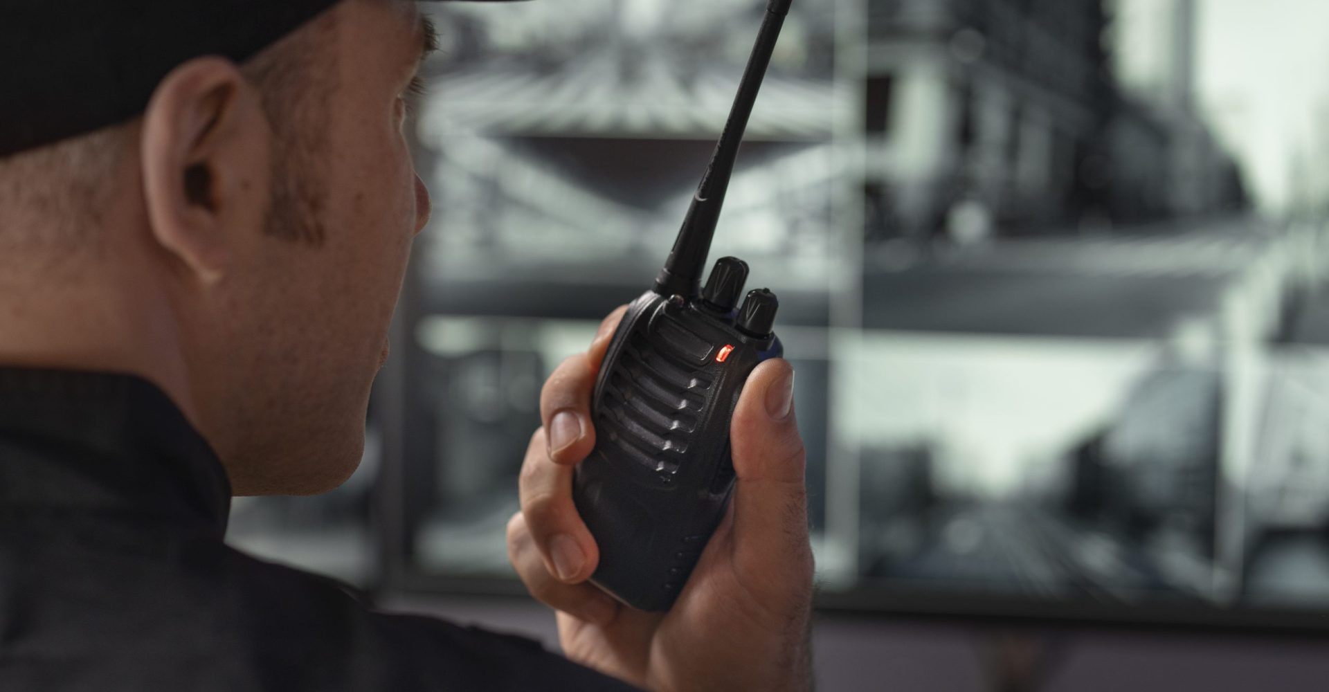 portrait-male-security-guard-with-radio-station-camera-screens